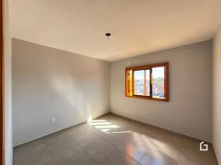 Ambiente interno de uma sala com piso de cerâmica e janela.
