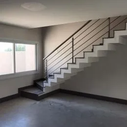 Foto de um corredor interno com escadaria e janela.