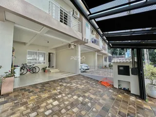 Vista da fachada de uma residência em Lajeado, Brasil, com área externa pavimentada.