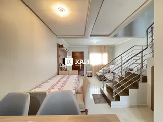 Quarto com cama e escadaria em um ambiente interno bem iluminado.