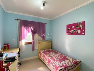 Quarto com parede azul claro e janela decorada com cortinas roxas.