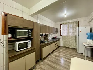 Uma cozinha com armários de madeira e piso de madeira em um imóvel no Brasil.