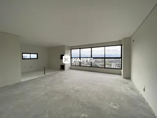 Ambiente interno amplo com piso de concreto e grande janela de vista para a paisagem.