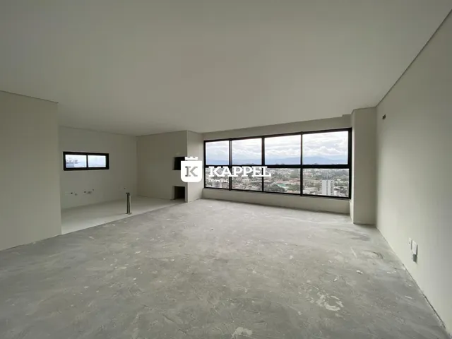 Ambiente interno amplo com piso de concreto e grande janela de vista para a paisagem.