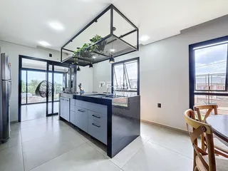 Vista da cozinha moderna com ilha e portas de vidro em Lajeado.