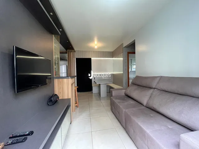 Sala de estar com sofá e televisão em um apartamento.