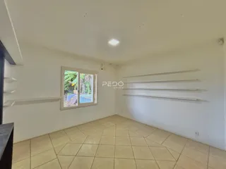 Ambiente interno de uma sala com piso de cerâmica e janela.