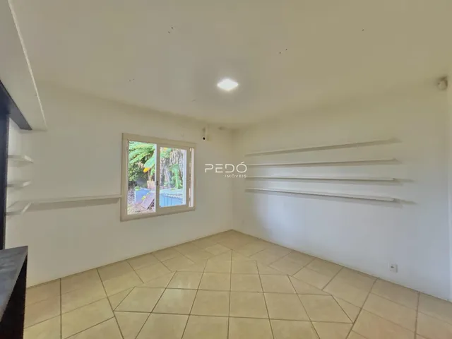 Ambiente interno de uma sala com piso de cerâmica e janela.