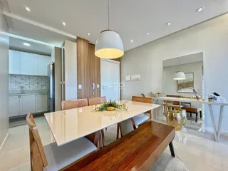 Uma sala de jantar moderna com mesa grande e ambiente claro.