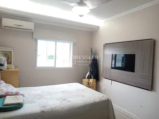 Quarto com janela e cama em ambiente claro.