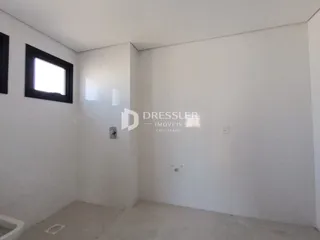 Foto de um ambiente interno com paredes brancas e uma janela.