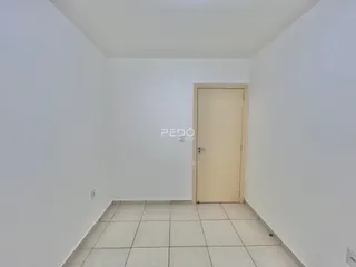 Foto de um cômodo interno com paredes brancas e piso de cerâmica.