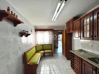 Ambiente interno com bancadas de madeira e piso cerâmico.