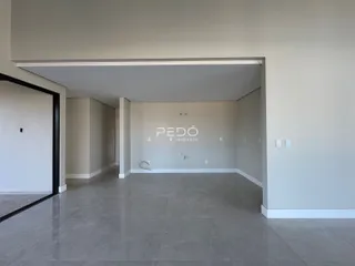 Um corredor interno com paredes brancas e piso de cerâmica.