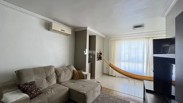 Sala de estar com sofá e janela iluminada.