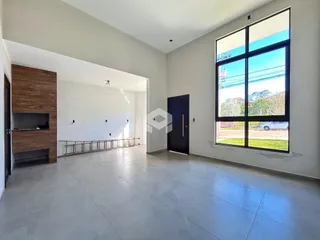 Ambiente interno de uma sala ampla com grande janela.
