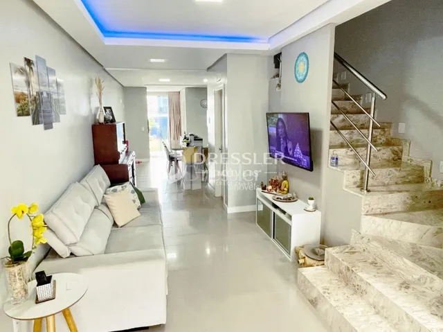 Vista de um corredor com escadaria em uma residência.