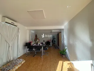Sala de jantar com piso de cerâmica e janela na sala.