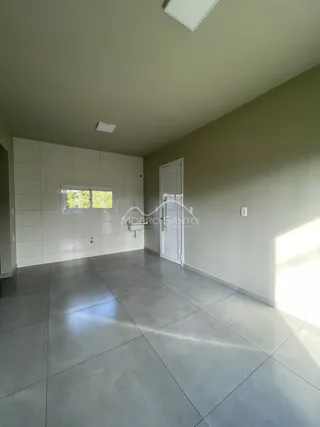 Hall de entrada com piso de porcelanato e paredes brancas.