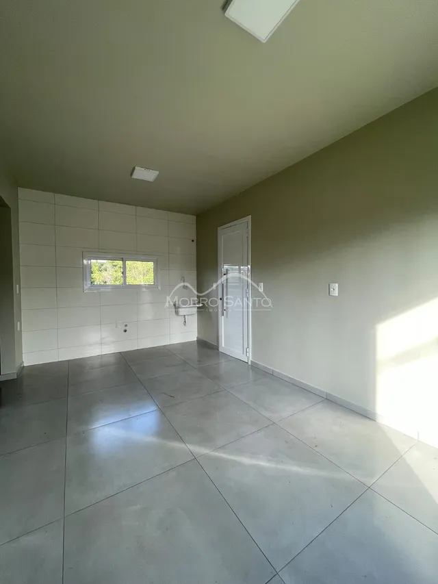 Hall de entrada com piso de porcelanato e paredes brancas.
