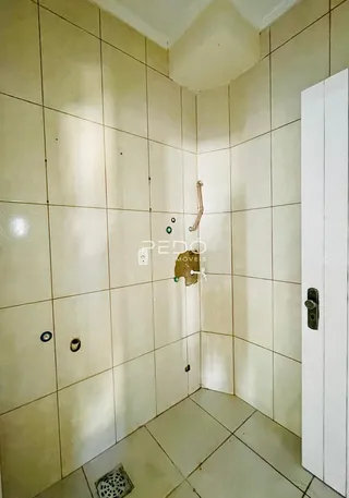 Uma foto de um ambiente interno com paredes de azulejo claro.