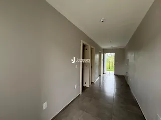 Corredor interno de uma residência com piso de cerâmica.