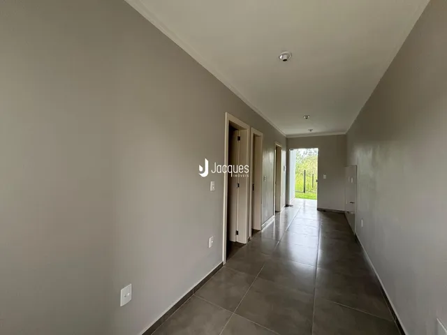 Corredor interno de uma residência com piso de cerâmica.