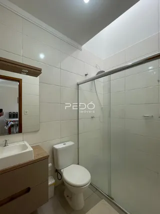 Foto de um banheiro com box de vidro e vaso sanitário.