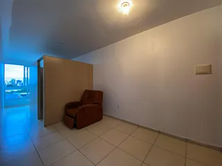 Ambiente interno com piso de cerâmica e uma poltrona em uma sala de estar.