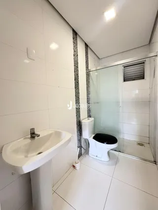 Foto de um banheiro com pia e box de vidro em um imóvel.
