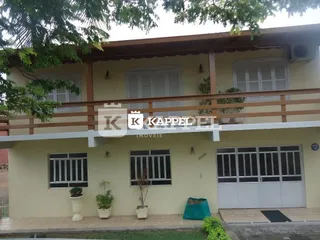 Fachada de uma casa em Lajeado, Brasil, com paredes claras e telhado.