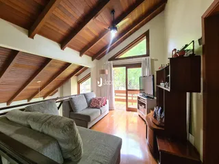 Sala de estar com teto de madeira e grandes janelas em Lajeado, Brasil.