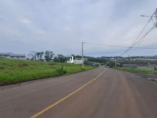 Vista da rua e terreno com vegetação ao fundo em Lajeado, Brasil.