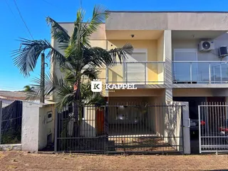 Fachada de um prédio residencial em Lajeado, Brasil, com cerca e palmeira em primeiro plano.