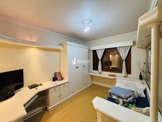Quarto com armários embutidos e piso de madeira clara.