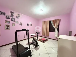 Foto de uma sala de estar com piso de cerâmica e equipamentos de ginástica.