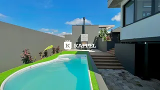 Foto da piscina externa com paisagismo verde em uma residência.