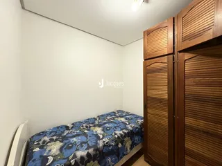 Quarto com cama e armário de madeira na sala.