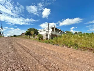Fachada de uma casa em Lajeado, Brasil, ao lado de uma estrada de terra.