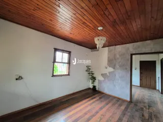Interior de uma sala com piso de madeira e teto de madeira.