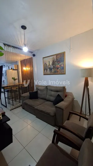 Sala de estar com sofá e piso de madeira em um imóvel no Brasil.