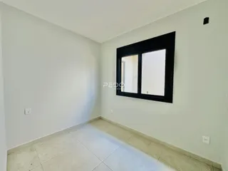 Ambiente interno de uma sala com paredes brancas e piso de cerâmica.
