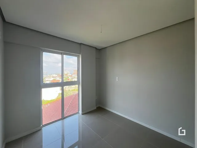 Ambiente interno com piso de cerâmica e grande janela.