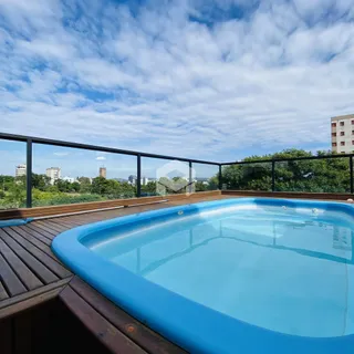 Vista de uma piscina e deck com vista para a paisagem urbana.