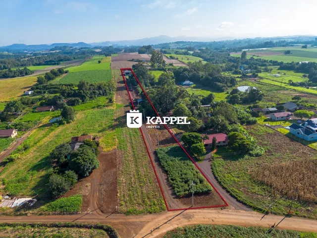 Vista aérea de uma propriedade rural cercada por campos e vegetação.