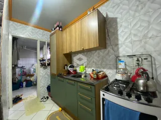 Vista da cozinha com armários de madeira e eletrodomésticos.