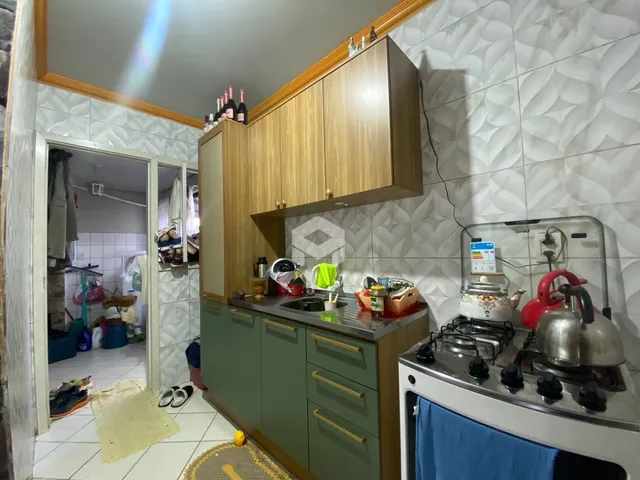 Vista da cozinha com armários de madeira e eletrodomésticos.