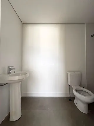 A foto mostra um banheiro com pia e vaso sanitário brancos.