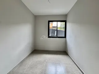 Hall de corredor com paredes brancas e uma janela.