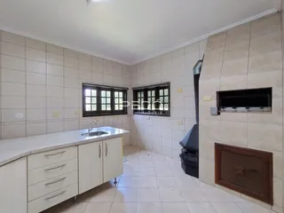 Foto de uma cozinha com armários brancos e piso de cerâmica.
